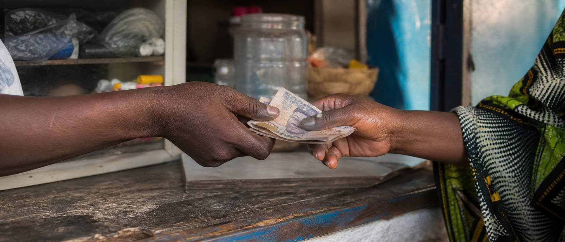 A customer handing cash across the counter to an agent
